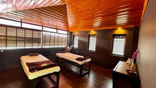 a room with two beds in a room with wooden ceilings at The Chumbi Mountain Retreat & Spa, A Club Mahindra Associate in Pelling