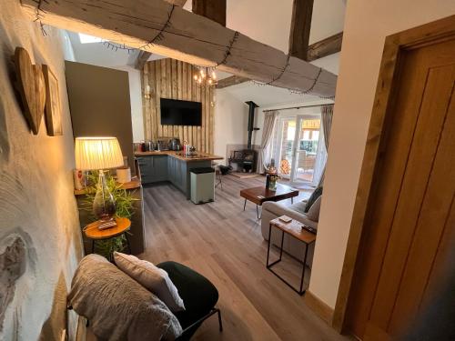 a living room with a couch and a table at Tanyard Barn - Luxury Hot Tub & Secure Dog Field Included in Old Glossop