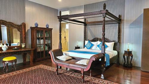 a bedroom with a canopy bed and a chair at Nayara Villa Desa Budo in Wori