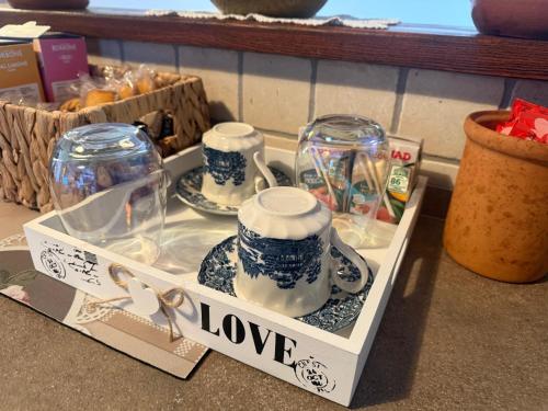 a box with two cups and jars on a table at Athena Casa Vacanze in Campello sul Clitunno