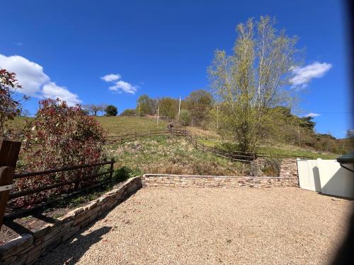 a stone pathway with a fence and a field at Tanyard Barn - Luxury Hot Tub & Secure Dog Field Included in Old Glossop