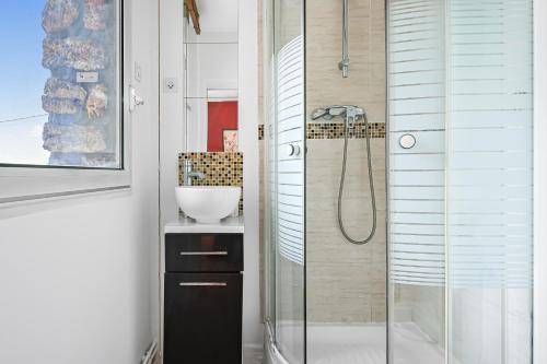 une salle de bain avec une douche en verre et un lavabo dans l'établissement Le Chic - Chambre cosy aux portes de Paris, à Bagneux