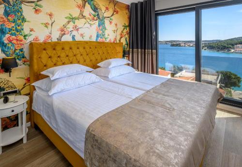 a bedroom with a large bed with a large window at Apartments Penthouse lux XYZ in Rogoznica
