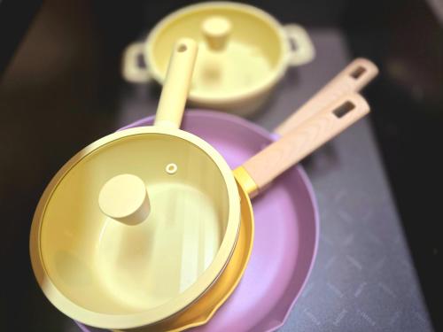 two pots and pans sitting on a purple plate at 머물다 울산 울산공항 5분 태화강역10분 울산 병영성 in Ulsan