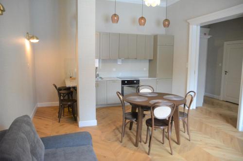 a kitchen and dining room with a table and chairs at Browar Hevelius Apartments by Grand Apartments in Gdańsk