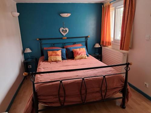 une chambre avec un lit avec un mur bleu dans l'établissement Logis de Paty, à Lagny-sur-Marne