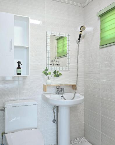 a white bathroom with a sink and a toilet at 머물다 울산 울산공항 5분 태화강역10분 울산 병영성 in Ulsan