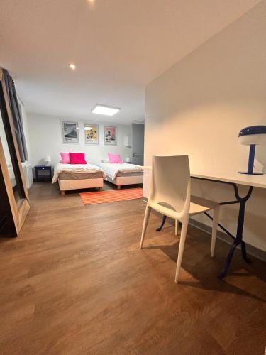 a room with a desk and a bed and a couch at Appartement rétro nature avec jardin 15 min Toulouse centre in Saint-Geniès-Bellevue