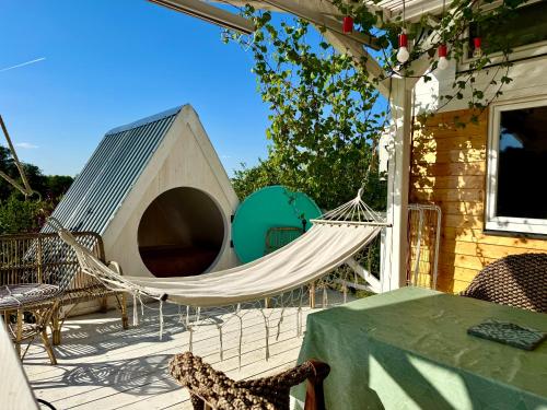 a hammock on the back patio of a house at Bohemian ECO lodge in Kisapáti