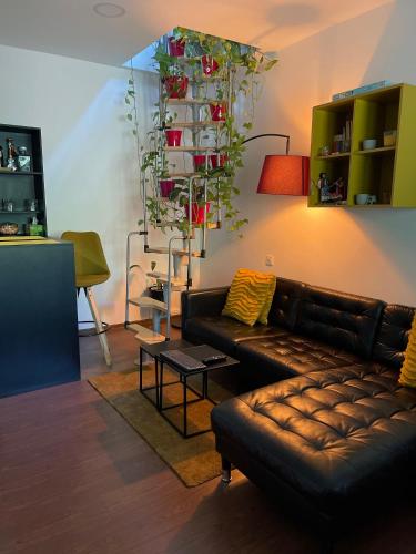 a living room with a leather couch and a table at City Garden Apartments in Bucharest