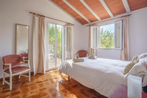 a bedroom with a bed and a large window at Can Miquel pollensa in Pollença
