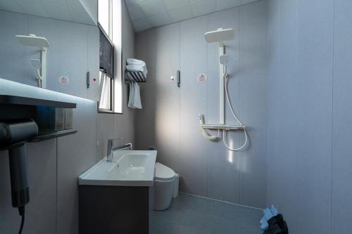 a bathroom with a shower and a toilet and a sink at Wuyi Whispering Maple in Dali