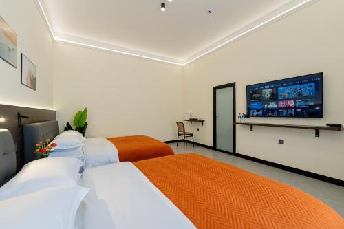 a bedroom with two beds and a flat screen tv at Wuyi Whispering Maple in Dali