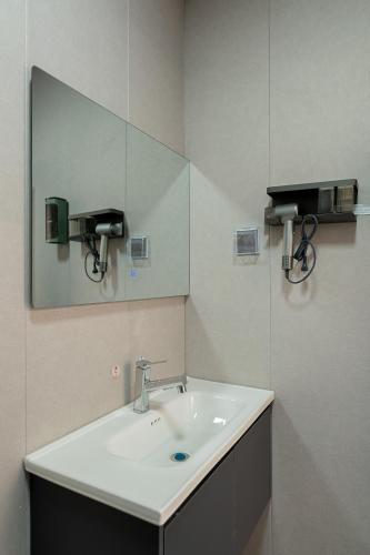 a bathroom with a sink and a mirror at Wuyi Whispering Maple in Dali