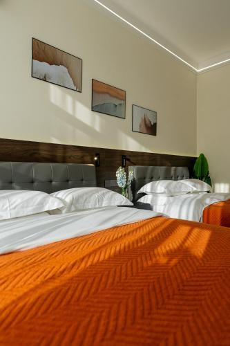 two beds in a bedroom with an orange blanket at Wuyi Whispering Maple in Dali