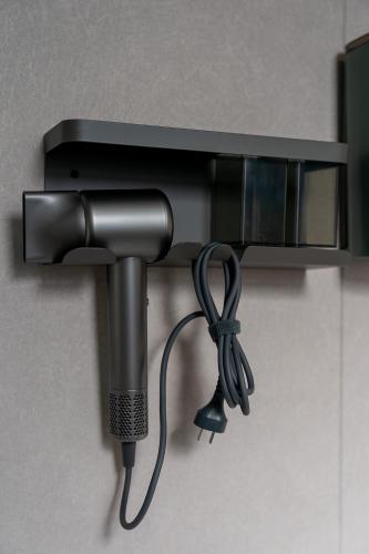 a hair dryer hanging from a wall with a microphone at Wuyi Whispering Maple in Dali
