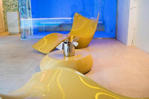 two yellow chairs and a table in a room at Olea Suites in Alcalá del Júcar