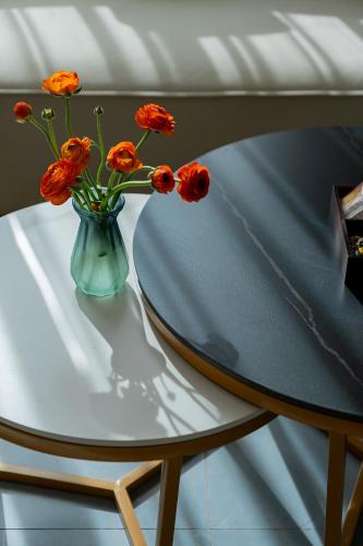 a vase with orange flowers sitting on a table at Wuyi Whispering Maple in Dali