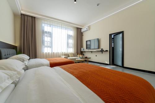 a hotel room with two beds and a living room at Wuyi Whispering Maple in Dali