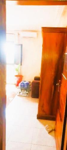 a room with a wooden door and a white tile floor at Teranga Ancienne Piste Mermoz in Dakar