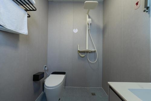 a bathroom with a white toilet and a sink at Wuyi Whispering Maple in Dali
