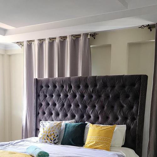 a bed with a black headboard in a bedroom at Cozy 4 Bedroom Holiday Home in Kisii