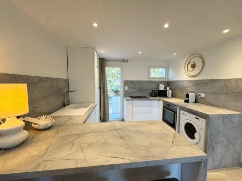 une cuisine avec un lave-linge et un sèche-linge sur un comptoir dans l'établissement Logement vue mer et plage à pied, à Sainte-Maxime