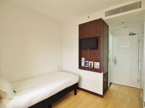 a small bedroom with a bed and a tv at ibis Hong Kong North Point in Hong Kong