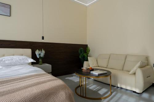 a bedroom with a bed and a couch and a table at Wuyi Whispering Maple in Dali