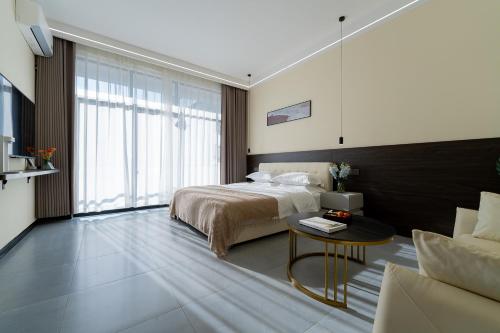 a bedroom with a bed and a table and a couch at Wuyi Whispering Maple in Dali