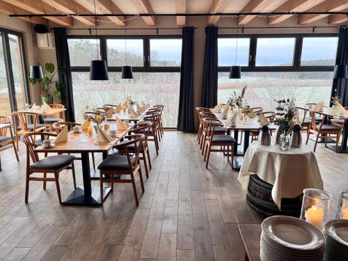 a dining room with tables and chairs and windows at Hotel Pflugsmühle in Abenberg