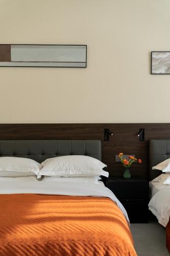 a bedroom with a large bed with an orange blanket at Wuyi Whispering Maple in Dali
