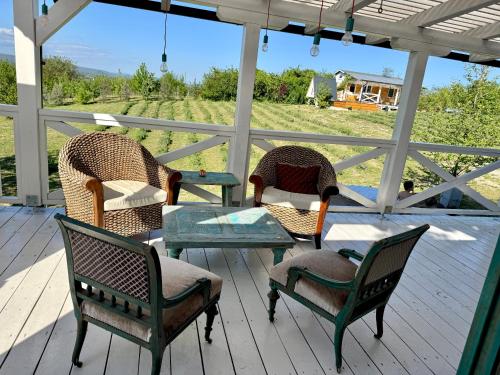 three chairs and a table on a porch with a view at Bohemian ECO lodge in Kisapáti