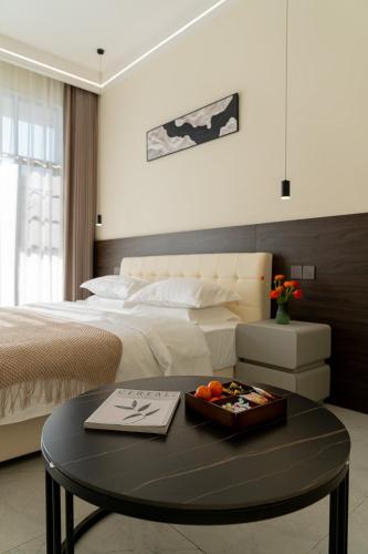 a bedroom with a bed and a table with a tray of fruit at Wuyi Whispering Maple in Dali