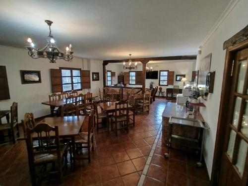 Un comedor con mesas y sillas de madera. en Albergue el Caseron de Fuentes Carrionas, en Cardaño de Abajo