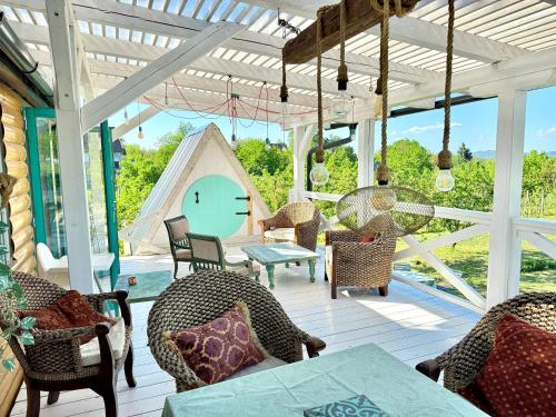 a porch with chairs and a table and a tent at Bohemian ECO lodge in Kisapáti