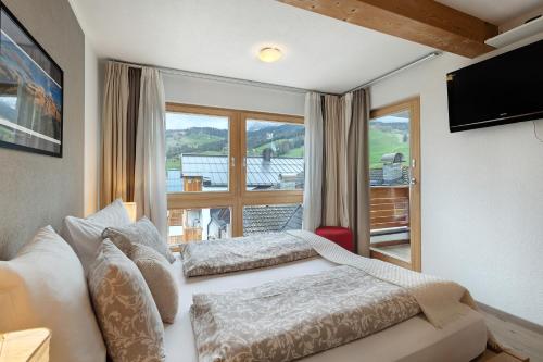 ラ・ヴィッラにあるCiasa Irene Dreizimmerwohnungのベッドが2つと大きな窓がある寝室