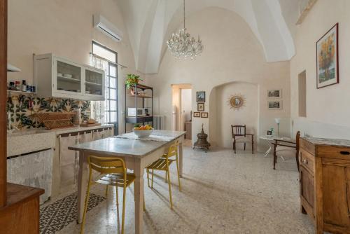 a kitchen with a table and chairs in a room at La Casa nel Borgo - Artemisia Homes in Nociglia