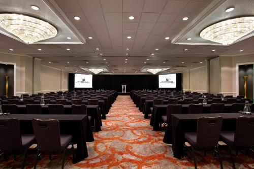 a conference room with tables and chairs and screens at The Whitehall Houston in Houston