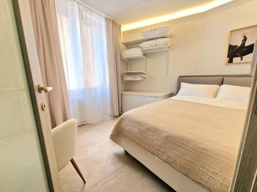 a small bedroom with a bed and a window at Lecco Antico Pozzo - Modern Suite in Lecco
