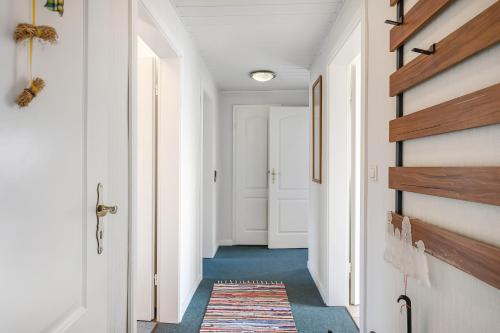 a hallway of a home with white walls and a rug at Wohnung Hallighof in Honkenswarft