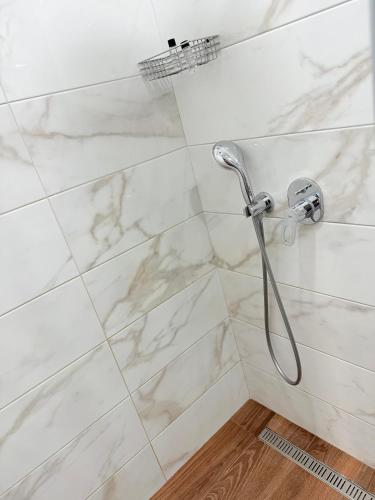 a bathroom with a shower with white marble tiles at Boutique Hotel Tiflis in Tbilisi City