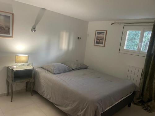 une chambre avec un lit et une table avec une lampe dans l'établissement Villa AKOA, à Aix-en-Provence