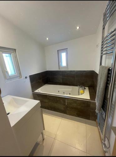 une grande salle de bain avec une baignoire et un lavabo dans l'établissement Villa AKOA, à Aix-en-Provence