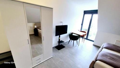 a living room with a large mirror and a table at Moderne Apartments mit Klima, perfekter Anbindung ins Zentrum und kostenlose Parkplätze! in Vienna