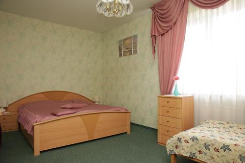a bedroom with a bed and a dresser and a window at Guest House Linas in Alytus