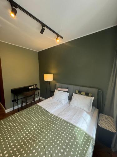 a bedroom with a bed and a table with a lamp at Avitar in Rīga