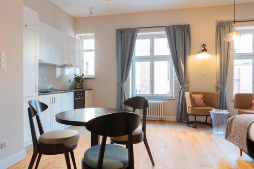 a kitchen and living room with a table and chairs at Browar Hevelius Apartments by Grand Apartments in Gdańsk