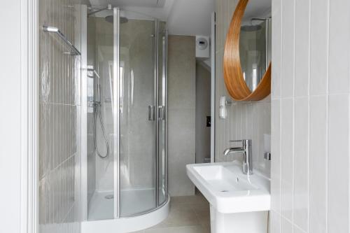 a bathroom with a shower and a toilet and a sink at Browar Hevelius Apartments by Grand Apartments in Gdańsk