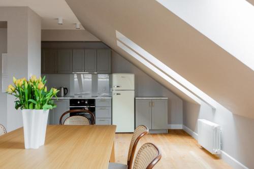 a kitchen and dining room with a table and chairs at Browar Hevelius Apartments by Grand Apartments in Gdańsk